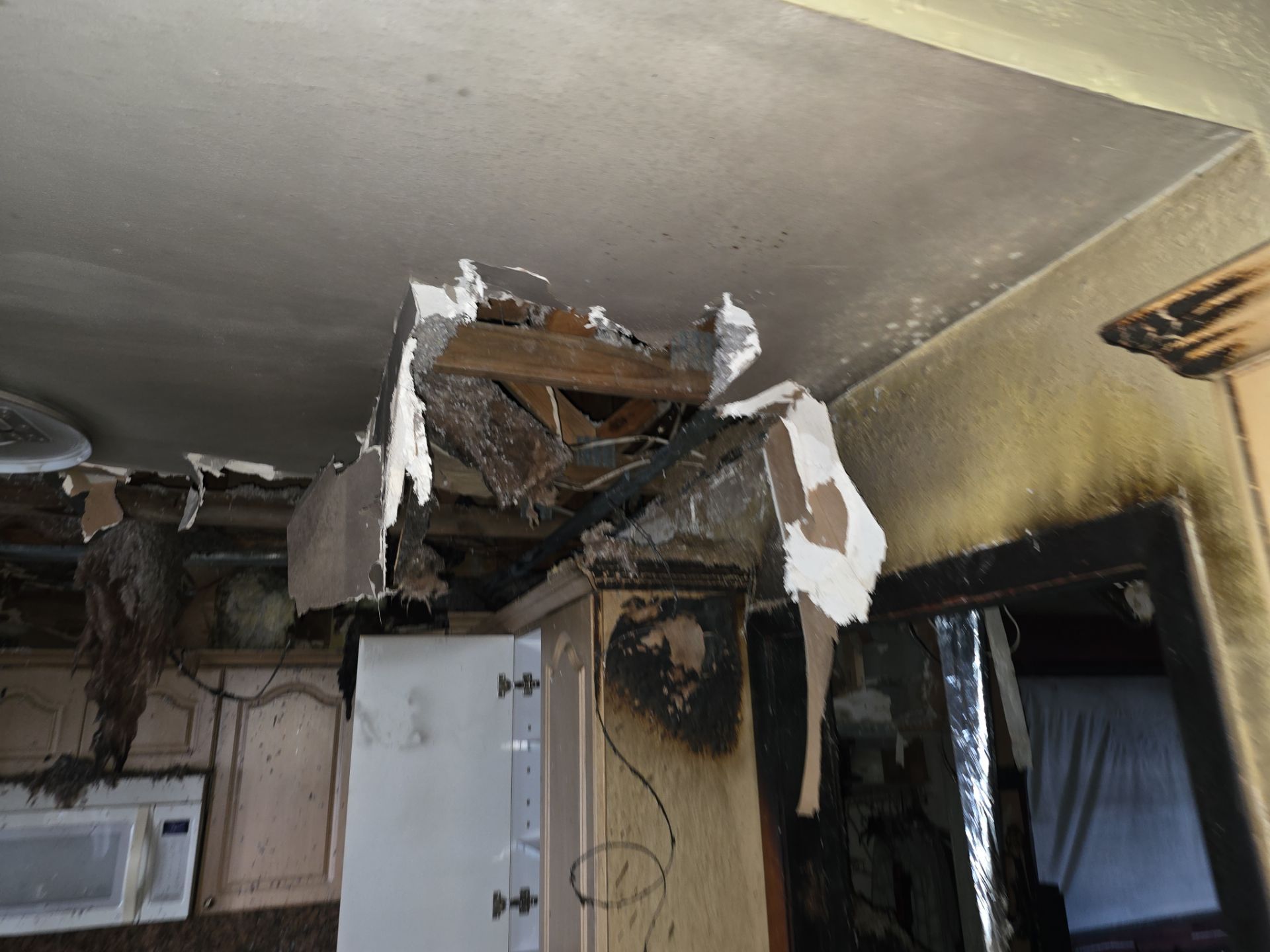 Collapsed ceiling and charred walls from residential fire